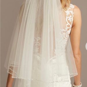New. Two tier fingertip veil, has a beaded edge for subtle sparkle.